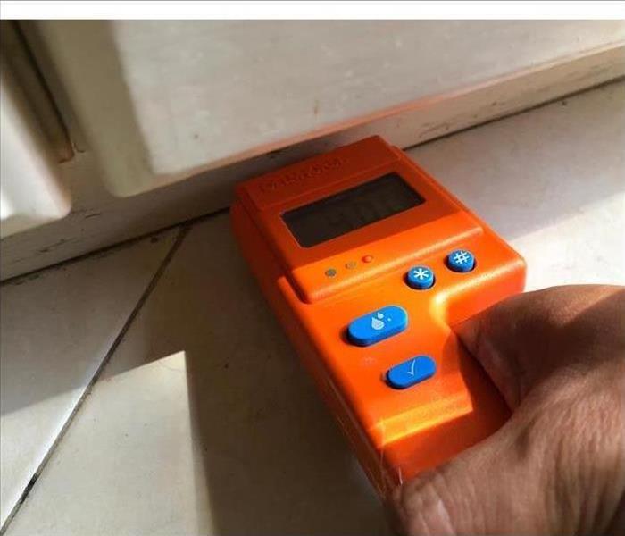 One of our technician using an orange device to measure the water content under this window 